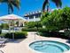 Resort-style pool and hot tub with lounge chairs, umbrellas, and lush landscaping at 396 Aruba Cir # 103, Bradenton, FL 34209