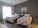 Well-lit bedroom with two twin beds and neutral wall color at 4470 Weybridge # 68, Sarasota, FL 34235