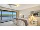 Comfortable bedroom with two twin beds and sliding doors leading to a deck with a water view at 5412 Siesta Cove Dr, Sarasota, FL 34242