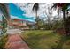 Large backyard with lush lawn and brick patio at 713 Eagle Point Dr, Venice, FL 34285