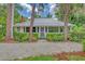 Charming yellow house with metal roof and manicured landscaping at 713 Eagle Point Dr, Venice, FL 34285