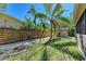 Landscaped backyard with shed, wooden fence, and palm trees at 7795 Wright Ave, Sarasota, FL 34231