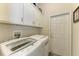Bright laundry room with washer, dryer, and ample cabinets at 11120 Sanctuary Dr, Bradenton, FL 34209