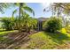 Screened patio and grassy backyard with palm trees at 12116 Maple Ridge Dr, Parrish, FL 34219