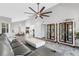 Open living room with gray sectional sofa, white ottoman, and built-in display cabinets at 1333 Perico Pointe Cir, Bradenton, FL 34209