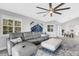 Living room features gray sectional sofa, ottoman, and views of the dining area at 1333 Perico Pointe Cir, Bradenton, FL 34209