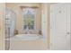 Relaxing bathroom with a soaking tub and large window at 1800 Scarlett Ave, North Port, FL 34289