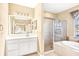 Bright bathroom with a large mirror, soaking tub, and separate glass enclosed shower at 1800 Scarlett Ave, North Port, FL 34289