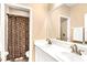 Bathroom with double sinks, a shower, and a patterned shower curtain at 1800 Scarlett Ave, North Port, FL 34289