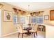 Charming dining area with a glass-top table, four chairs, and decorative window treatments at 1800 Scarlett Ave, North Port, FL 34289