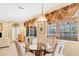 Bright dining area featuring a round glass table, four chairs, and elegant window coverings at 1800 Scarlett Ave, North Port, FL 34289