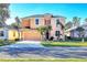 Two-story house with peach-colored exterior, two-car garage, and palm trees at 1800 Scarlett Ave, North Port, FL 34289