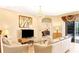 Living room with light leather sofas, a glass coffee table, and a large TV at 1800 Scarlett Ave, North Port, FL 34289