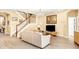 Cozy living room with a plush sofa, decorative chandelier, and stairway leading to the upper level at 1800 Scarlett Ave, North Port, FL 34289