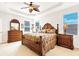 Elegant main bedroom with a tray ceiling, ceiling fan, and ample natural light from the windows at 1800 Scarlett Ave, North Port, FL 34289