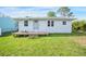 Cute one-story home with a wood deck and a well-maintained lawn at 208 36Th W St, Bradenton, FL 34205