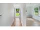 Hallway with light wood floors and views to a back door and living area at 208 36Th W St, Bradenton, FL 34205