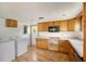 Efficient kitchen with wood cabinets, appliances, and laundry area at 208 36Th W St, Bradenton, FL 34205