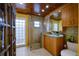 Modern bathroom with glass shower, wood cabinets, and granite vanity at 2690 Temple St, Sarasota, FL 34239