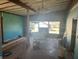 Bright living room with large windows and teal walls, ready for renovation at 308 E Hollywood St, Tampa, FL 33604