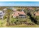 Aerial image of home with large screened patio, green yard, and golf course in the distance at 3408 Founders Club Dr, Sarasota, FL 34240
