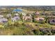 Aerial shot of the property, nestled among trees, other homes, a golf course and lake at 3408 Founders Club Dr, Sarasota, FL 34240