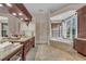 Luxurious bathroom with vanity, soaking tub, and large windows with natural light and elegant finishes at 3408 Founders Club Dr, Sarasota, FL 34240