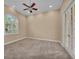 Empty bedroom featuring carpet, ceiling fan, shuttered window, and white french doors at 3408 Founders Club Dr, Sarasota, FL 34240