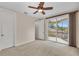 Bright bedroom with a ceiling fan, private balcony access with scenic views, and carpeted floors at 3408 Founders Club Dr, Sarasota, FL 34240