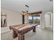 Game room featuring a pool table with Tiffany-style lighting and a bar with beautiful backyard views at 3408 Founders Club Dr, Sarasota, FL 34240