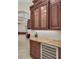 Hallway with granite countertops, dark wood cabinets, a wine refrigerator, and tiled floors at 3408 Founders Club Dr, Sarasota, FL 34240