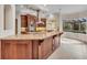 Bright kitchen featuring custom wood cabinetry, large island, and a window overlooking the pool at 3408 Founders Club Dr, Sarasota, FL 34240