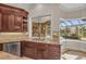 Kitchen sink area showcasing custom cabinetry, tile backsplash, and a view of the pool at 3408 Founders Club Dr, Sarasota, FL 34240