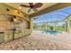 Covered outdoor kitchen with grill and sink, overlooking a private pool and lush landscaping at 3408 Founders Club Dr, Sarasota, FL 34240