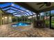 Covered patio with fireplace and comfortable seating near the pool at 3408 Founders Club Dr, Sarasota, FL 34240