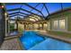 A luxurious screened-in pool with a spa and brick patio under a modern metal frame at 3408 Founders Club Dr, Sarasota, FL 34240