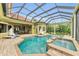 Spacious screened pool area with a spa, patio furniture, and an outdoor kitchen at 3408 Founders Club Dr, Sarasota, FL 34240