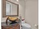 Powder room featuring vanity with granite countertop, bowl sink, decorative mirror, and fixtures at 3408 Founders Club Dr, Sarasota, FL 34240