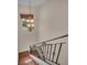 Elegant staircase features wrought iron railing and a decorative chandelier, illuminated by a window at 3408 Founders Club Dr, Sarasota, FL 34240