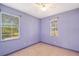 Bedroom with two windows, ceiling fan and purple walls at 5365 Matthew Ct, Sarasota, FL 34231