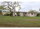 Large backyard with a grassy area and mature trees at 6203 Marina Dr, Holmes Beach, FL 34217