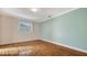 Bedroom with wood-look floors and a teal accent wall at 6725 Roxbury Dr, Sarasota, FL 34231