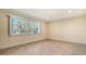 Light filled bedroom with neutral walls, tile flooring and large window at 6725 Roxbury Dr, Sarasota, FL 34231