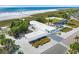 Aerial showcases the modern building near the beachfront, complemented by lush greenery and ocean views at 6725 Roxbury Dr, Sarasota, FL 34231