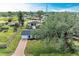 Aerial view of a single story home with brick paver driveway, large backyard, and surrounding neighborhood at 875 Royal Rd, Venice, FL 34293