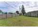 Large grassy backyard with wooden fence at 875 Royal Rd, Venice, FL 34293
