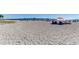 Expansive sandy beach with people relaxing under umbrellas, and the pier in the background at 875 Royal Rd, Venice, FL 34293
