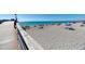 View from the pier showcasing the beach, ocean, and people enjoying the sunny day at 875 Royal Rd, Venice, FL 34293