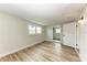 Bright bedroom with wood-look floors and an open door to another room at 875 Royal Rd, Venice, FL 34293