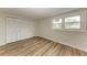 Bedroom with light walls, wood-look flooring, and white louvered doors at 875 Royal Rd, Venice, FL 34293